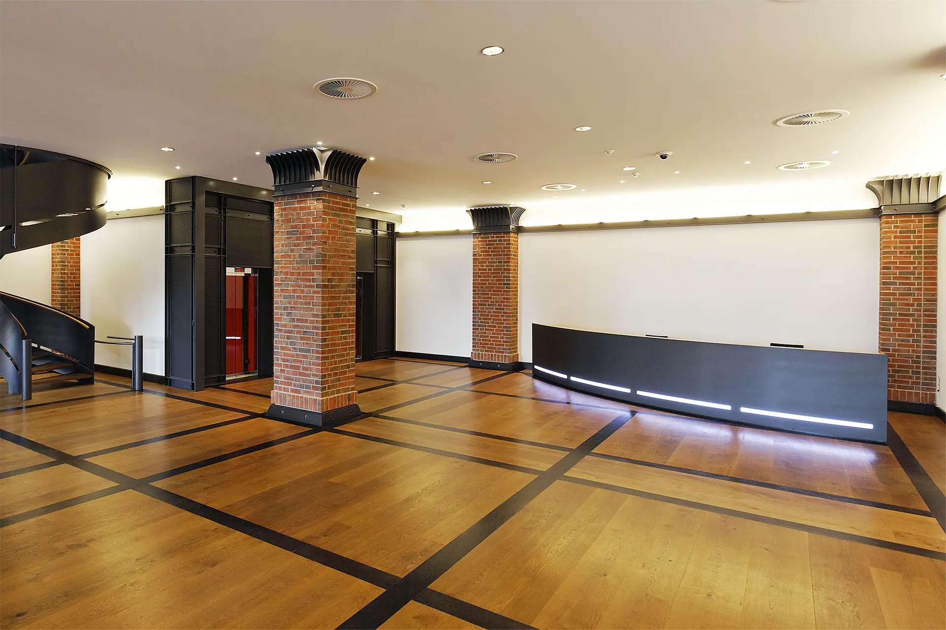 Empfangstresen aus anthrazitfarbenen Stahl und Eiche befindet sich in großer Eingangshalle.